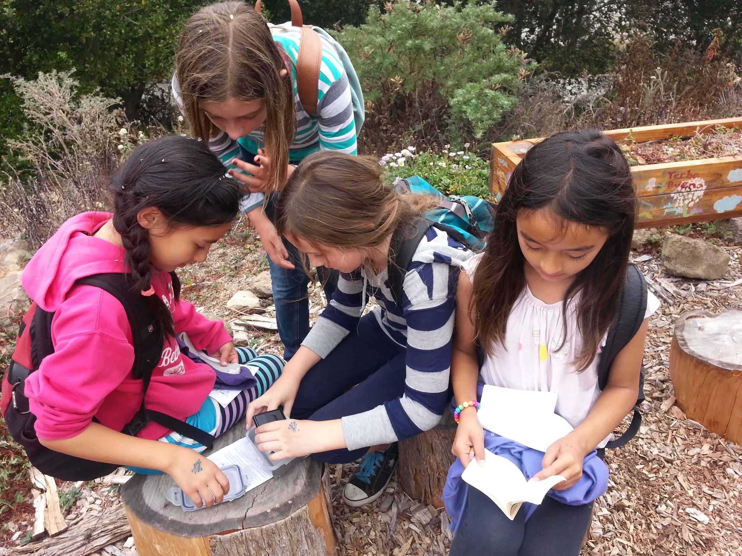 Four kids geocaching outdoors