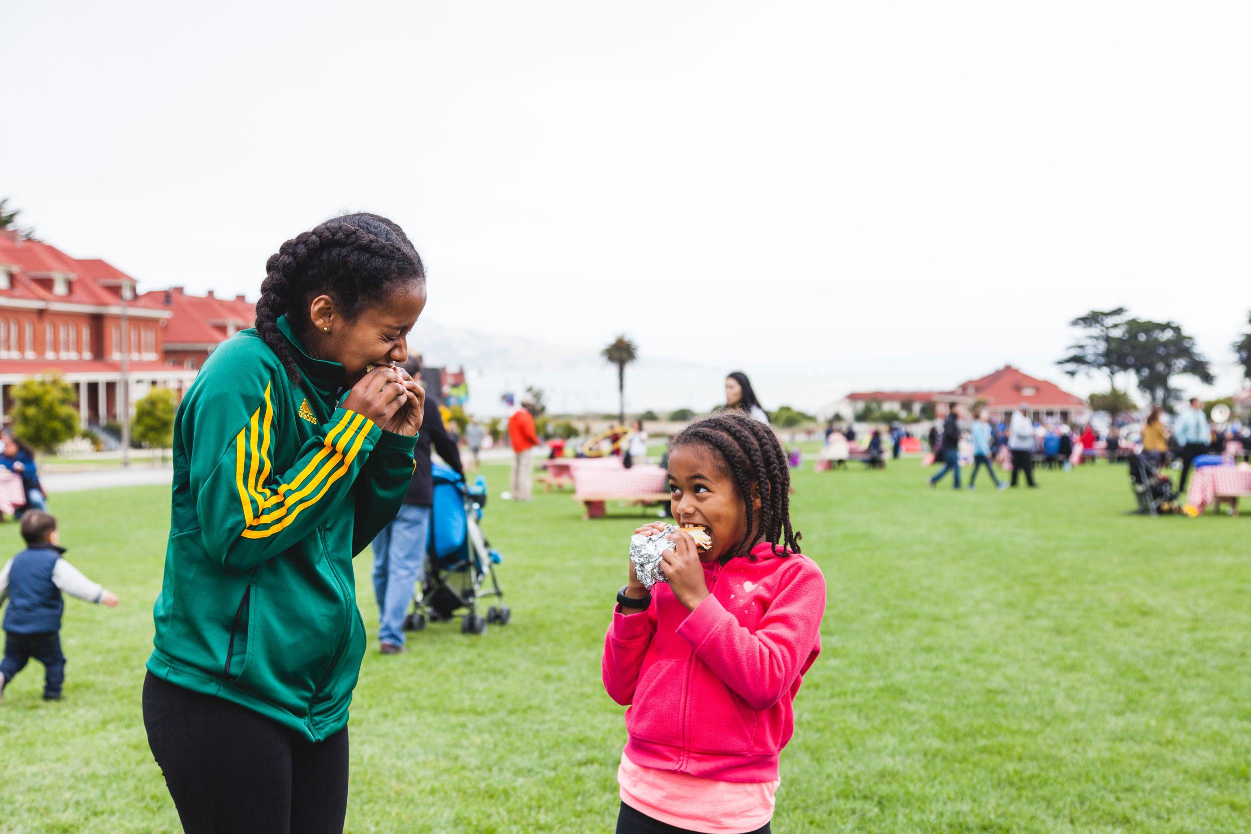 Woman and girl eating sandwiches on Main Parade Lawn