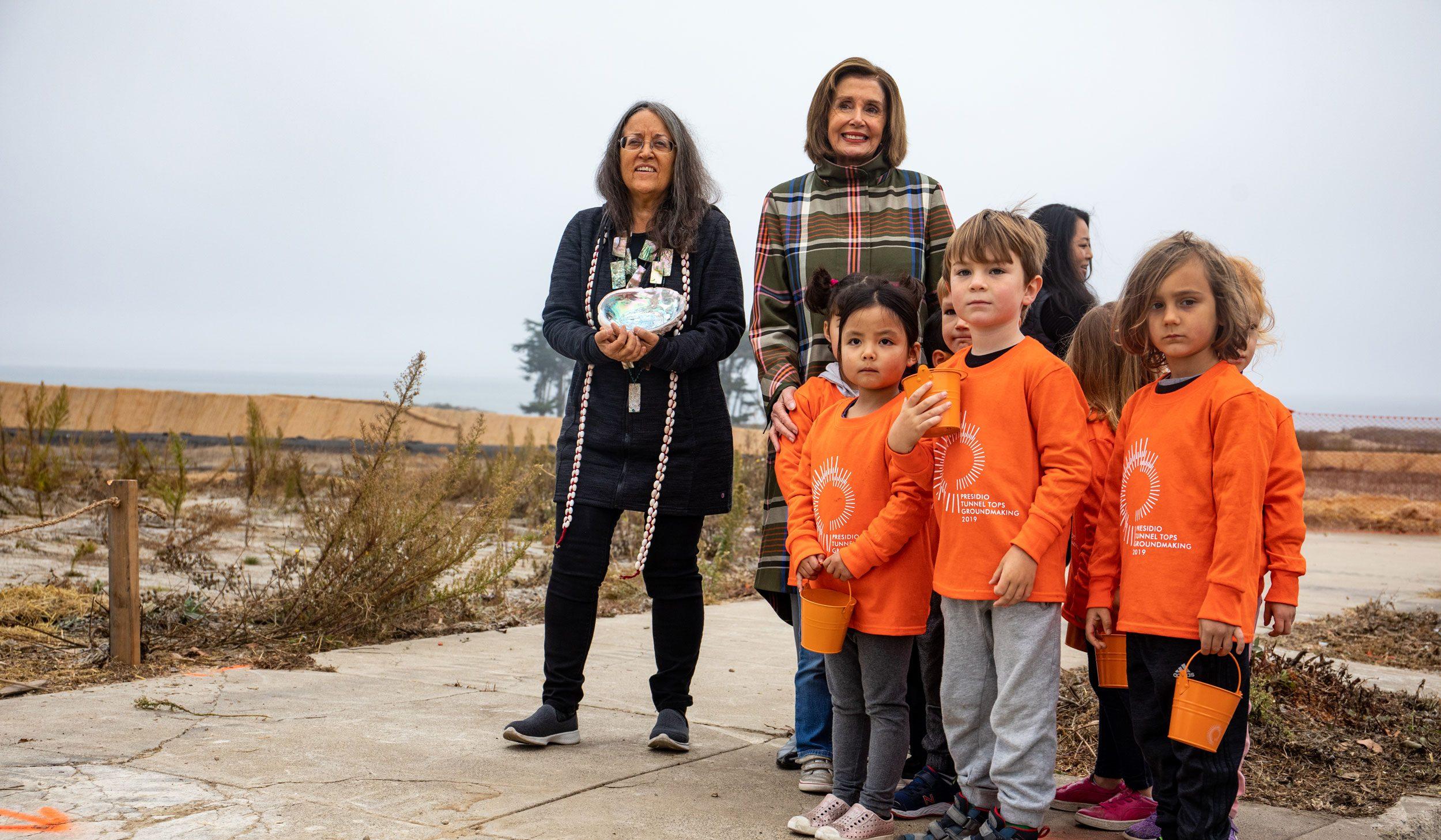 Nancy Pelosi with a community leader and group of children