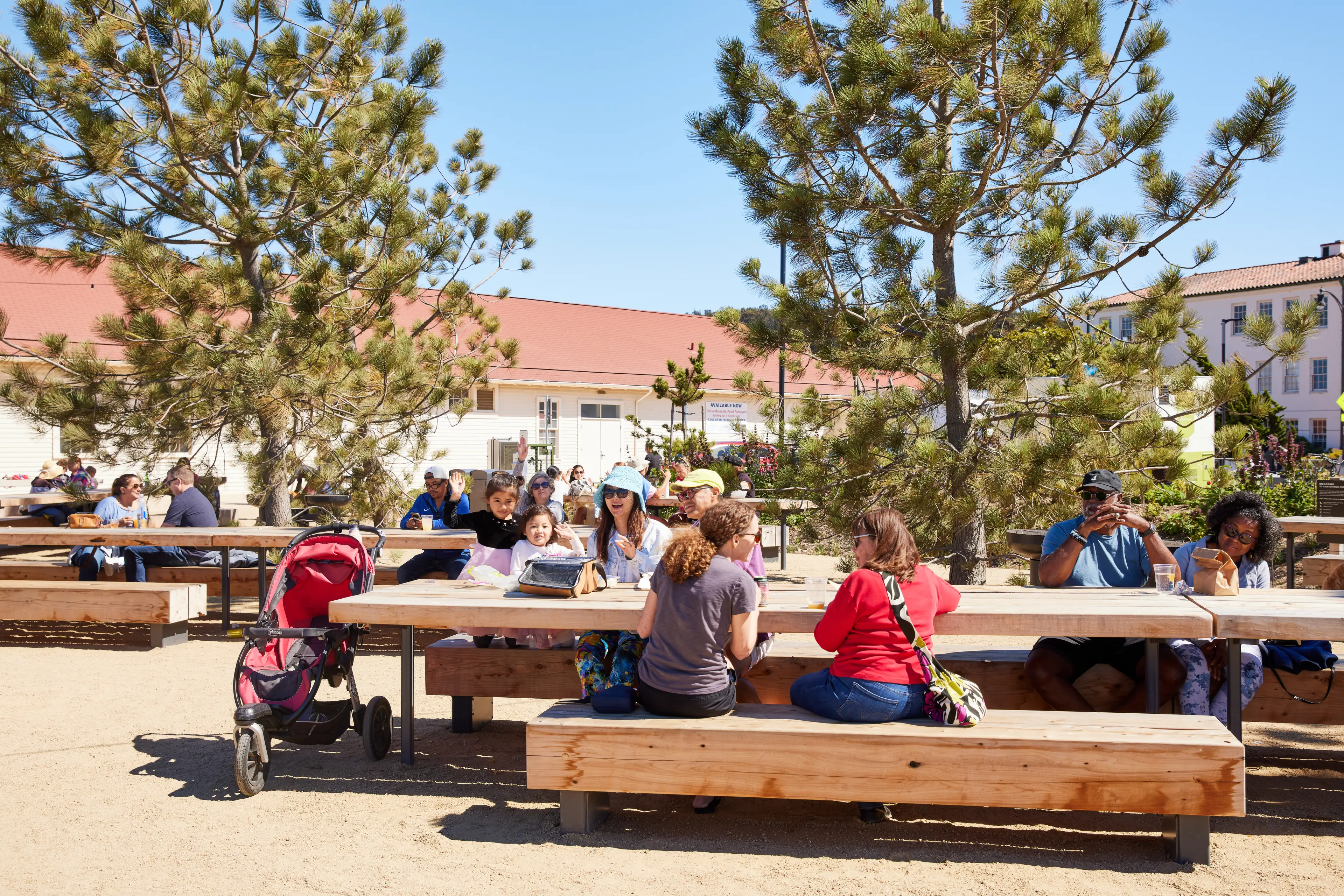 groups of people sitting an picnic tables at Presidio Tunnel Tops eating.