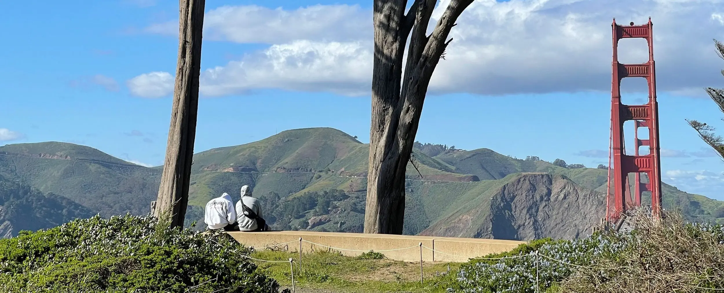 Two people admiring the view at the Golden Gate Overlook in the Presidio of San Francisco.