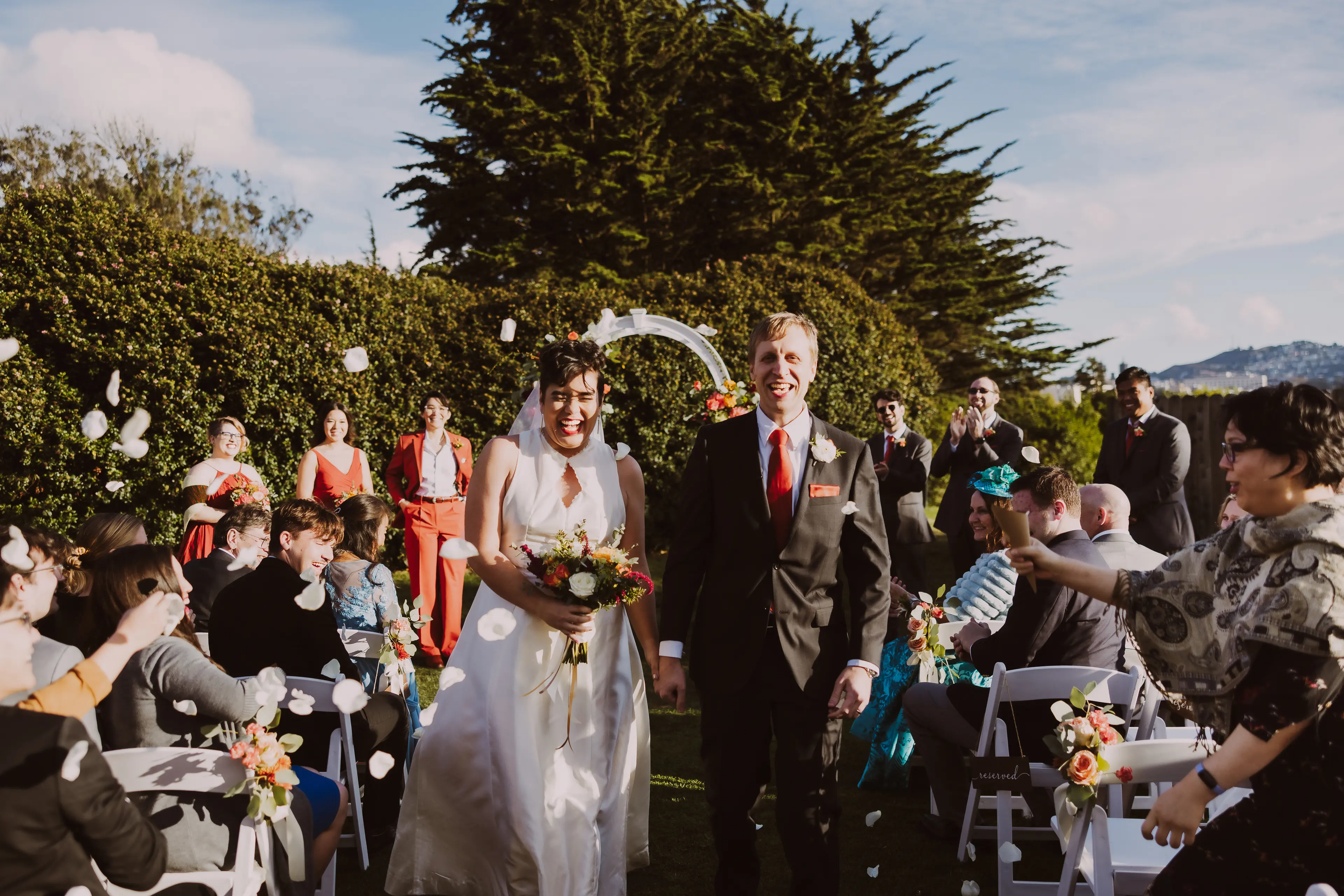 Newly married man and woman walking back down the aisle together at Presidio Golf Course