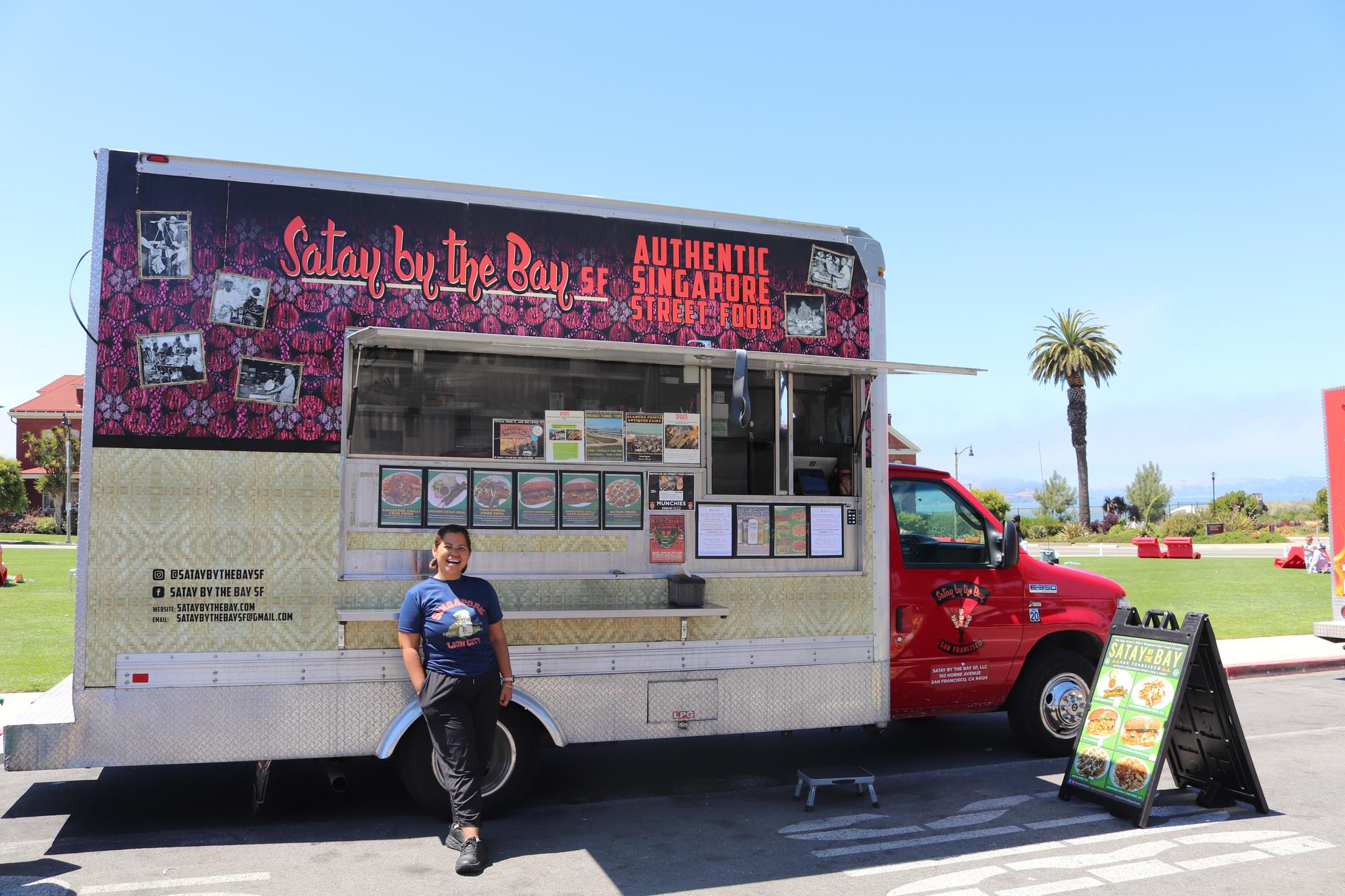 A woman standing in front of her food Truck, named Satay by the Bay, at Presidio Pop Up.