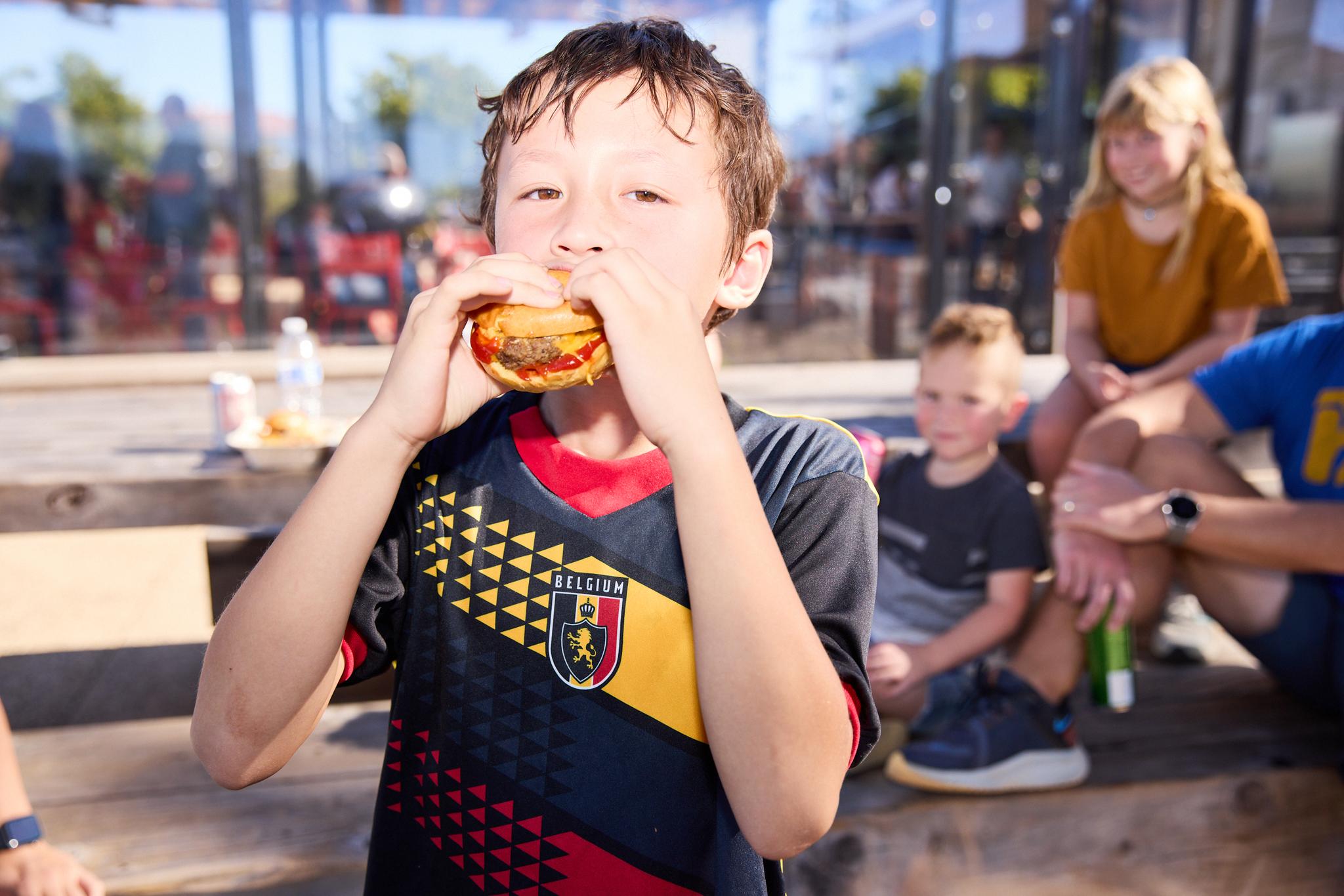 Young boy eating a cheeseburger at Presidio Tunnel Tops