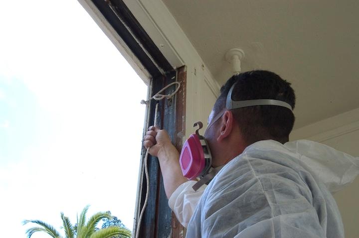 Worker repairs a historic sash rope.