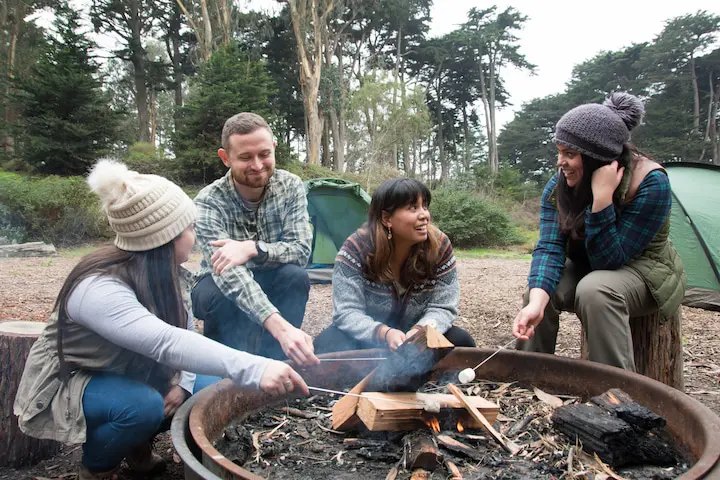 Four people hold marshmallows over the fire at Rob Hill Campground.