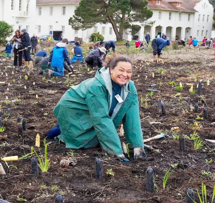 Woman planting a small plant at Fort Winfield Scott