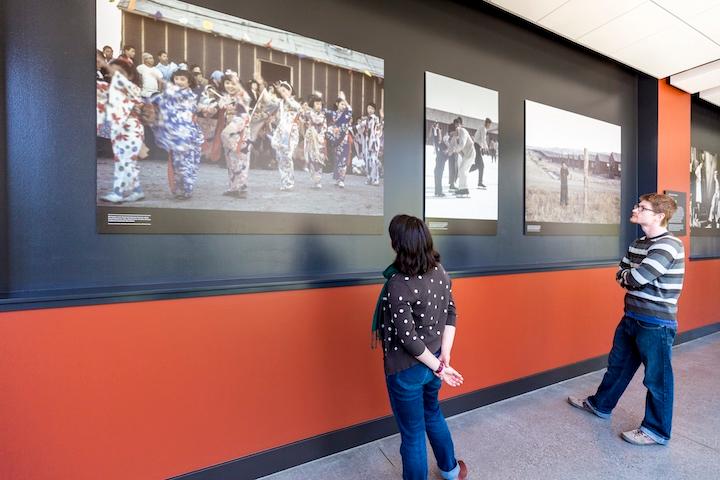 Two visitors looking at historic photos.