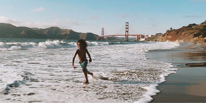Boy running on water at Baker Beach