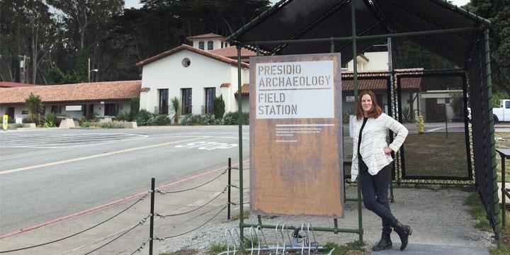 Kari Jones standing next to Presidio Archaeology Field Station sign