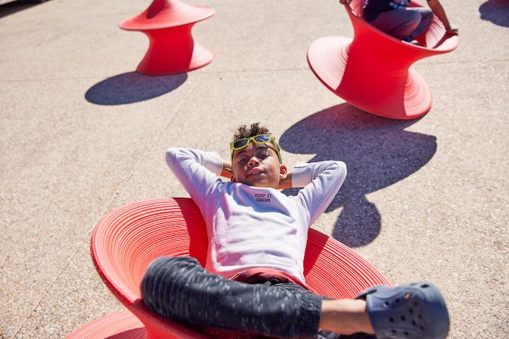 Boy on a red chair at Presidio Tunnel Tops. Photo by Rachel Styer.