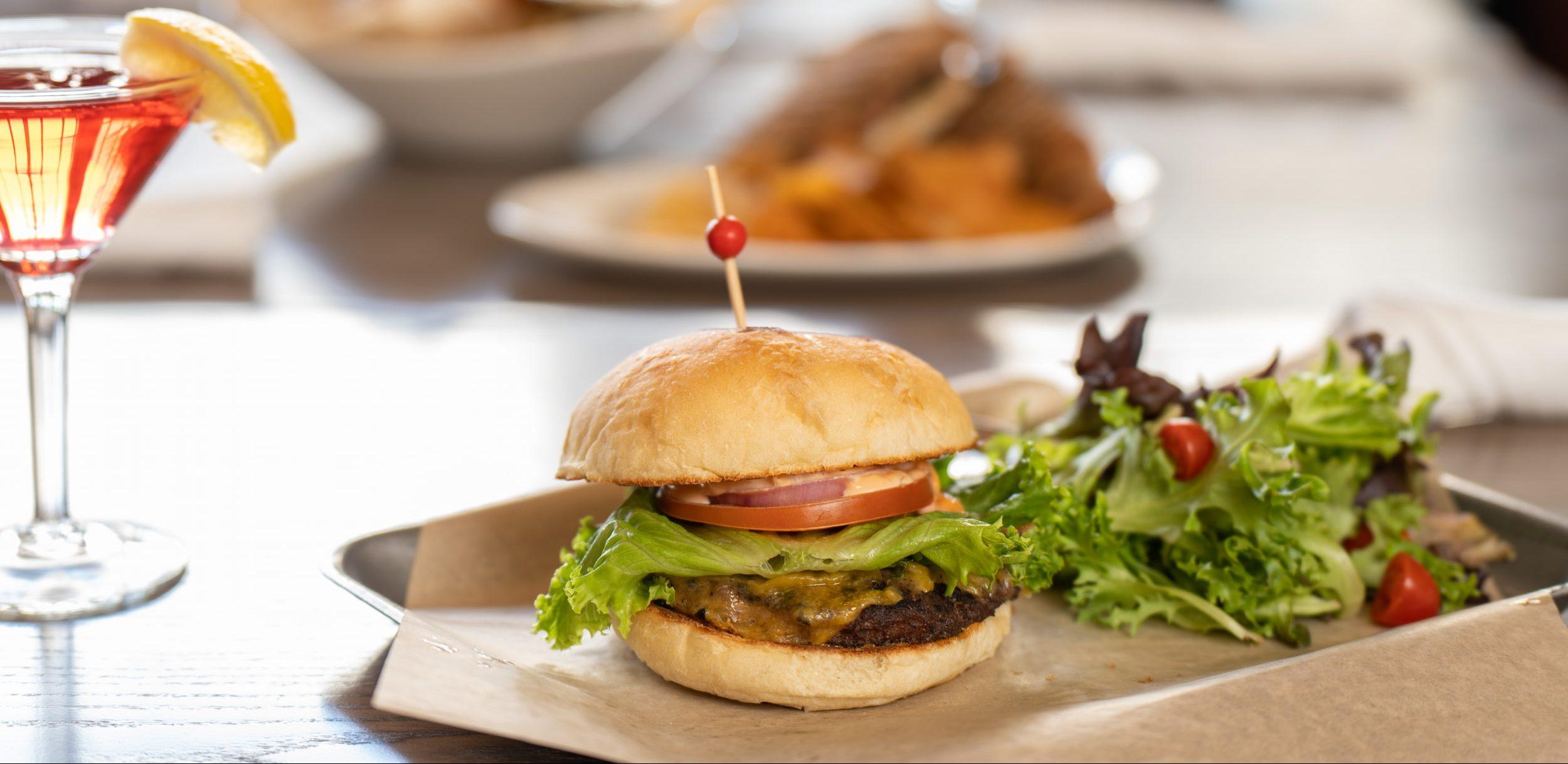 Photo of a table with a burger and beverages displayed. Photo by Danny Ferrell.