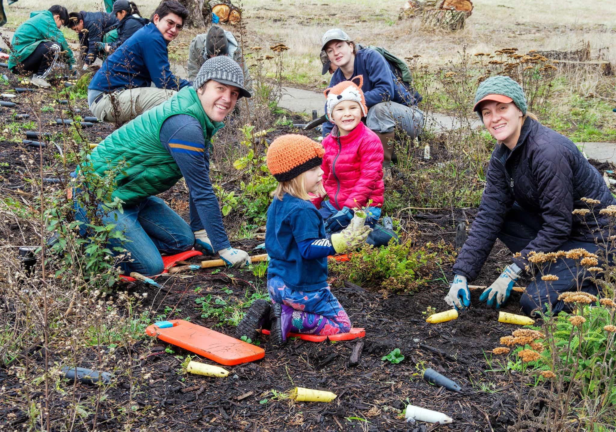 Group of adults and children planting