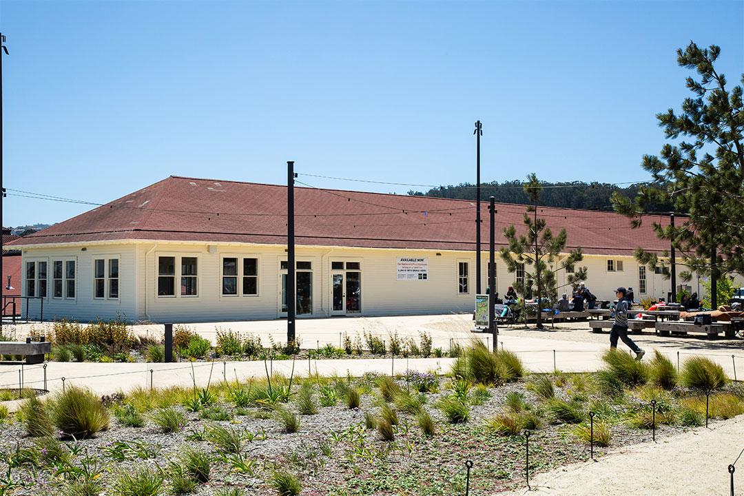 Exterior of Building 201 with outdoor picnic benches to the right