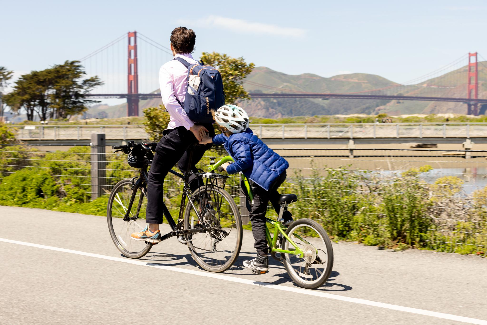 Father and son biking with the Golden Gate Bridge in the background.