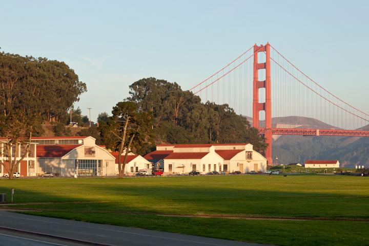 Building 937 along Crissy Field at sunrise with the Golden Gate Bridge in the background.