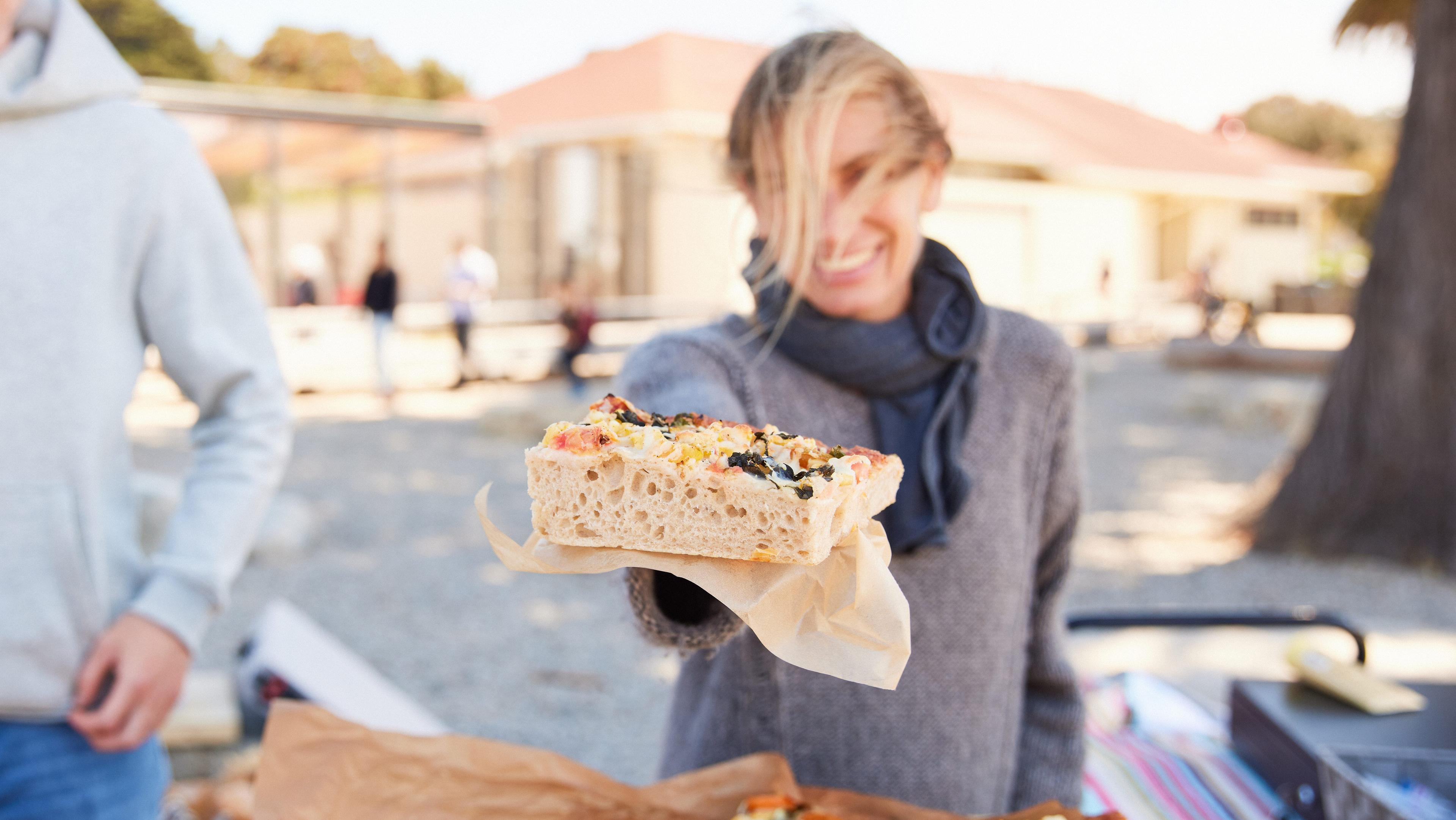 women holding out a sandwich