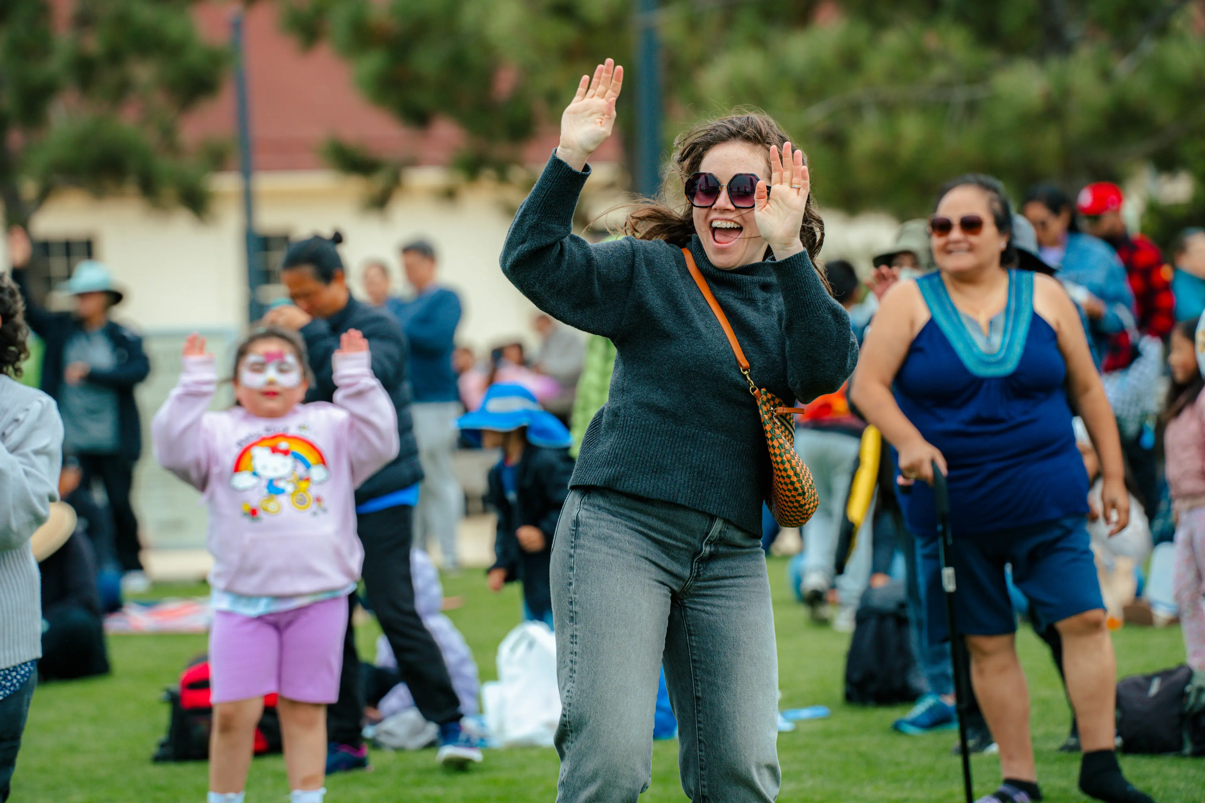 woman and child dancing with crowd dancing behind them