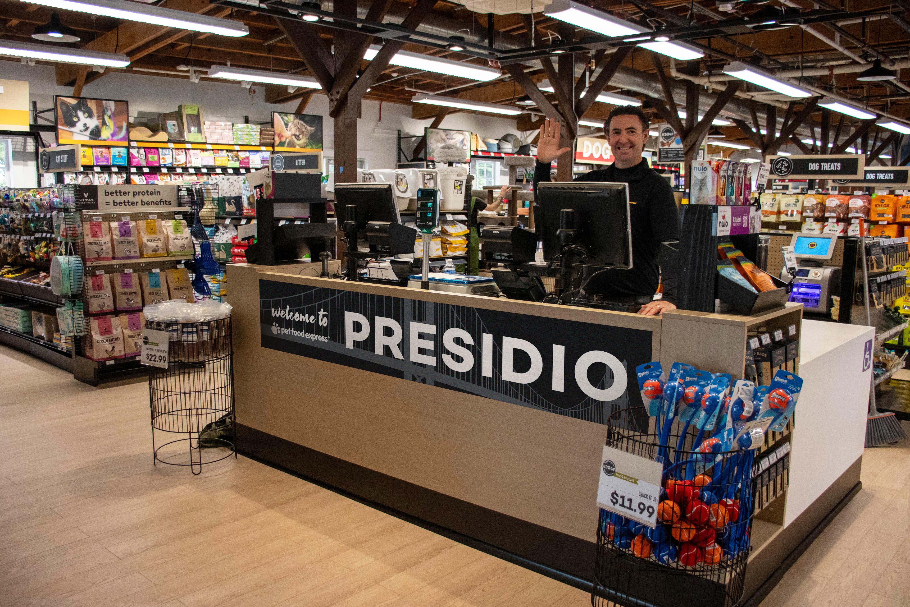 Pet Food Express Employee waving at counter