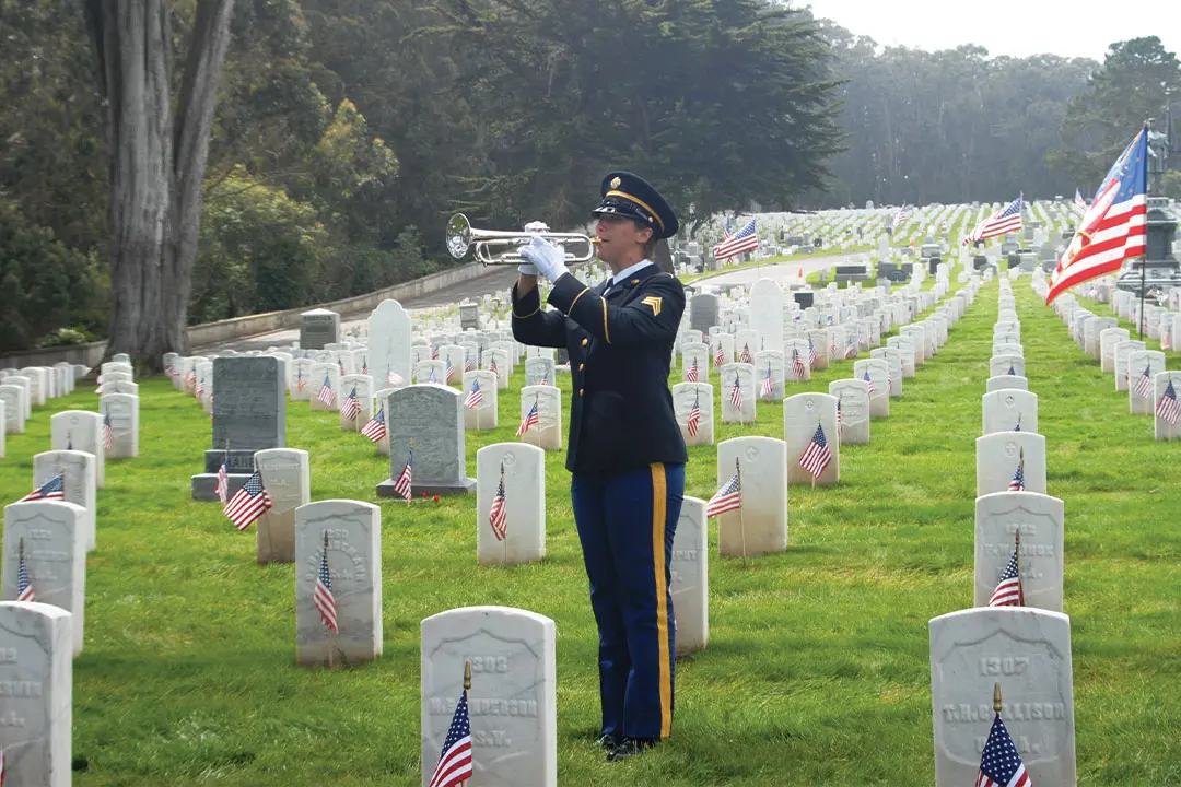 Man plays bugle at a ceremony.