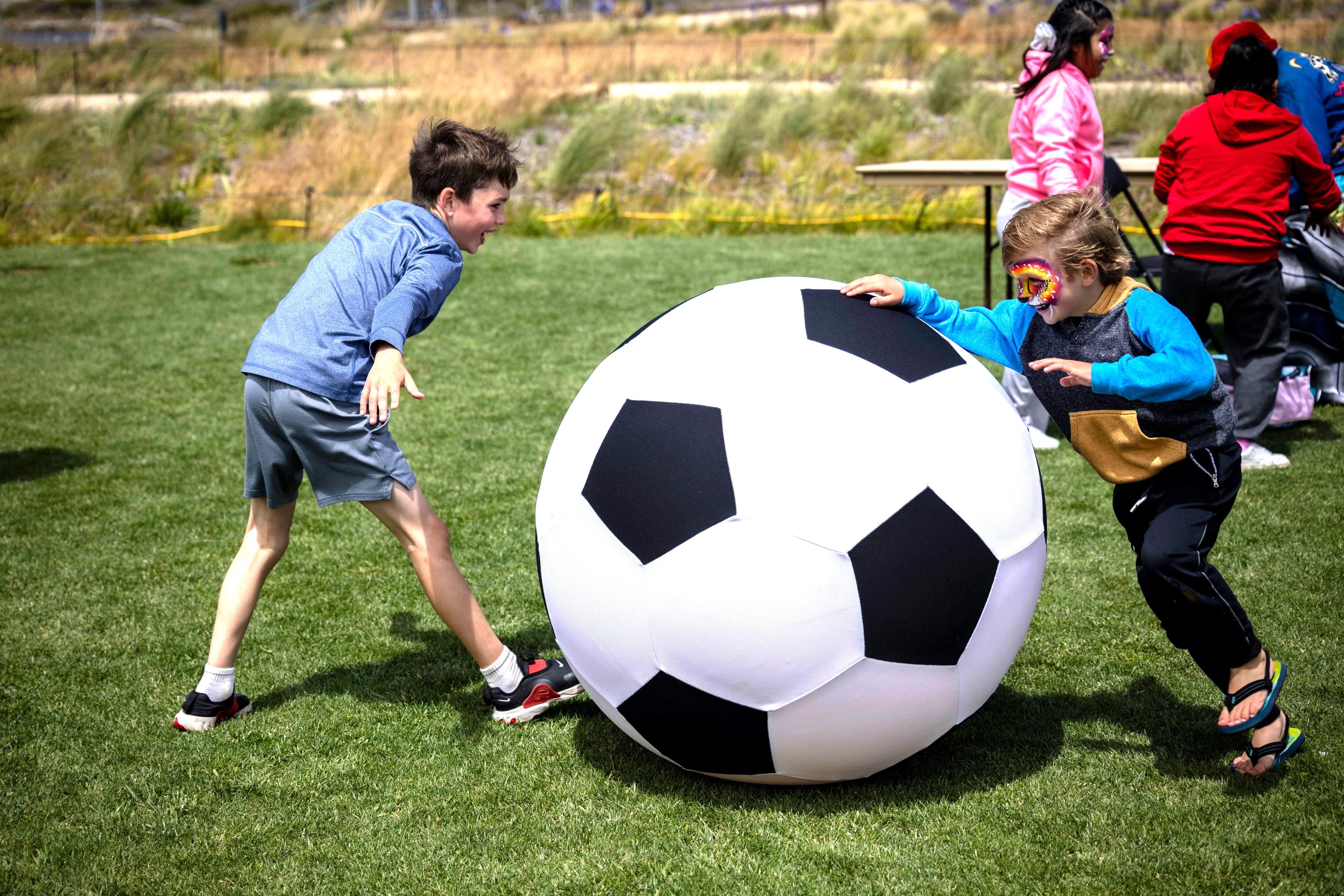 kids playing soccer with an oversized ball