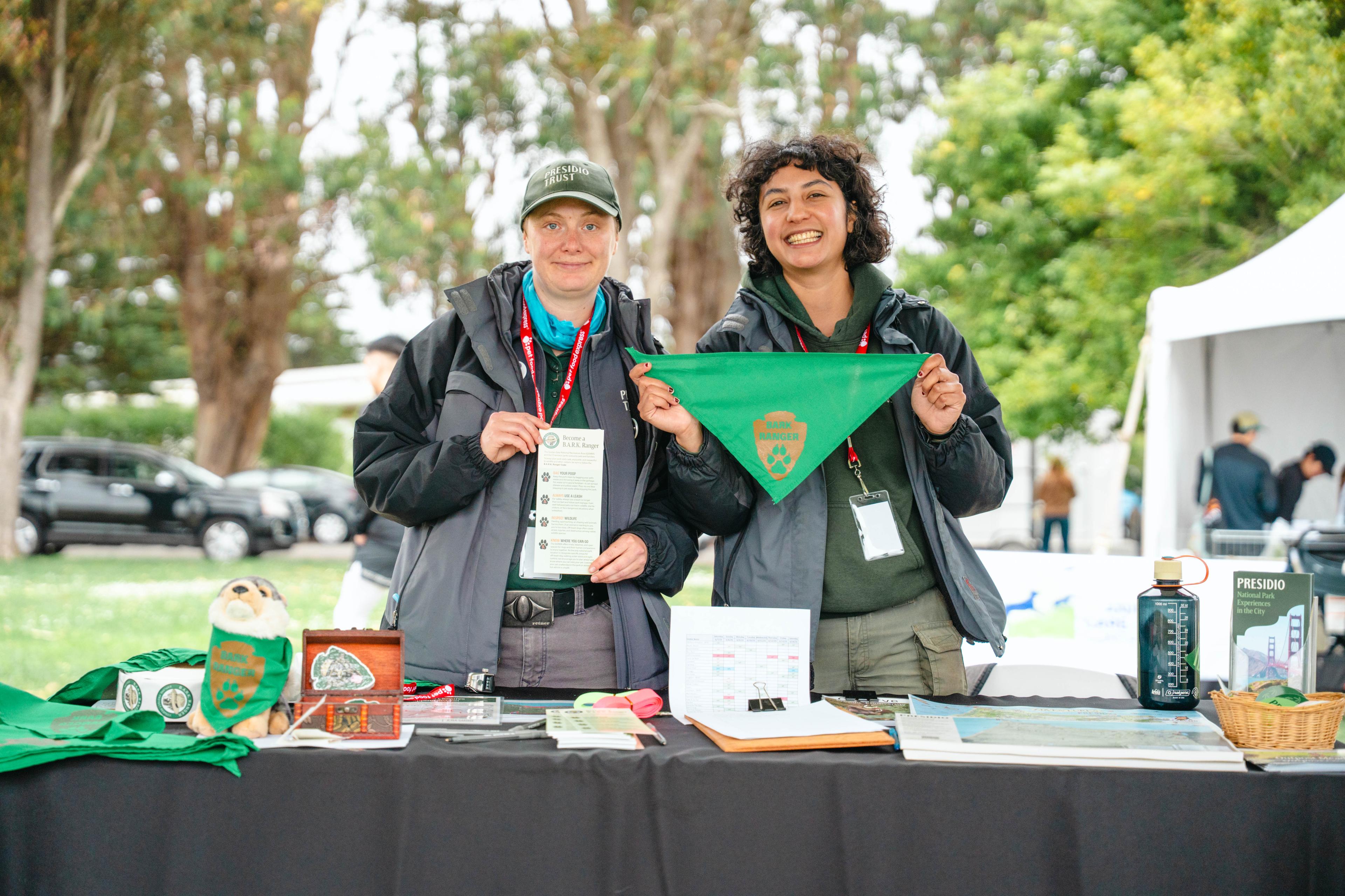 two women holding up BARK Ranger signs