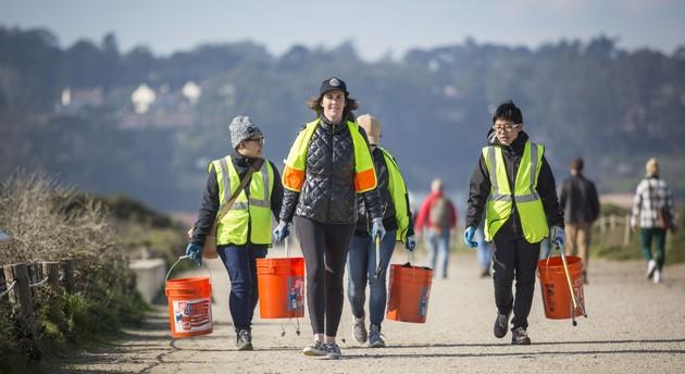 volunteers walking with buckets and protective vests