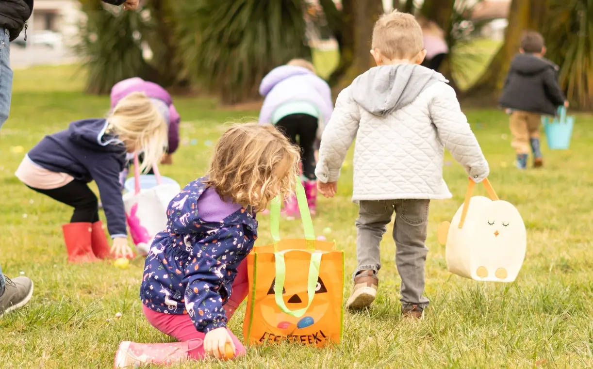 kids hunting for eggs on a lawn