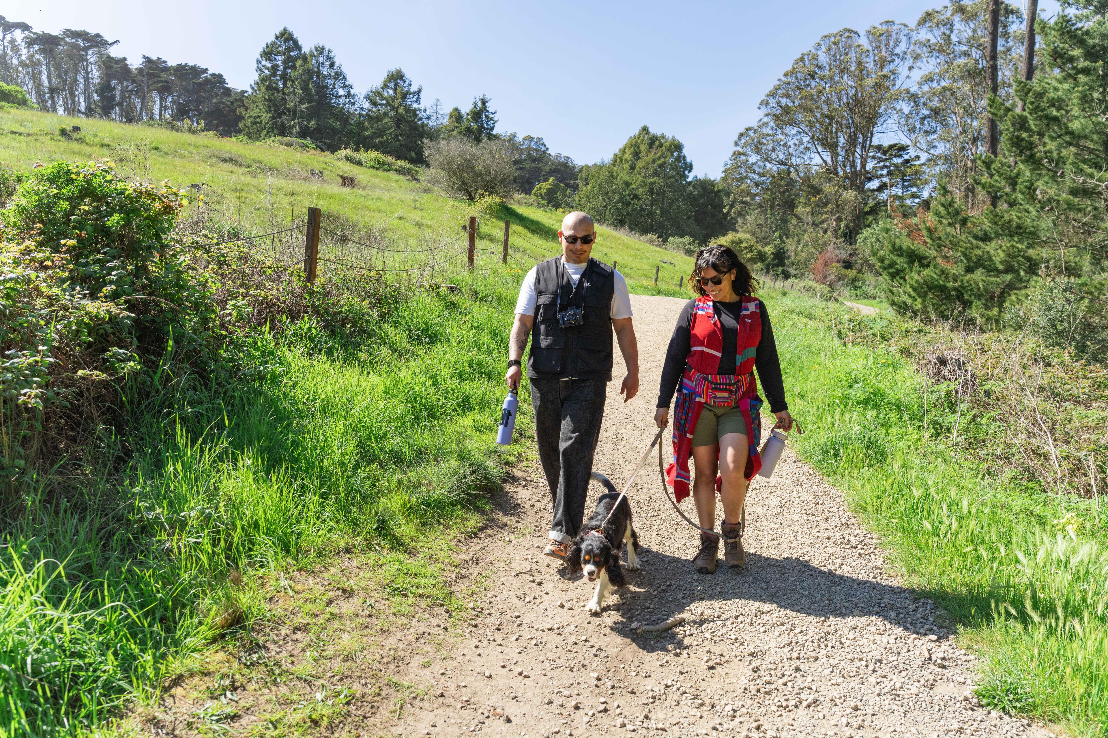 Couple walking along ecology trail with their dog