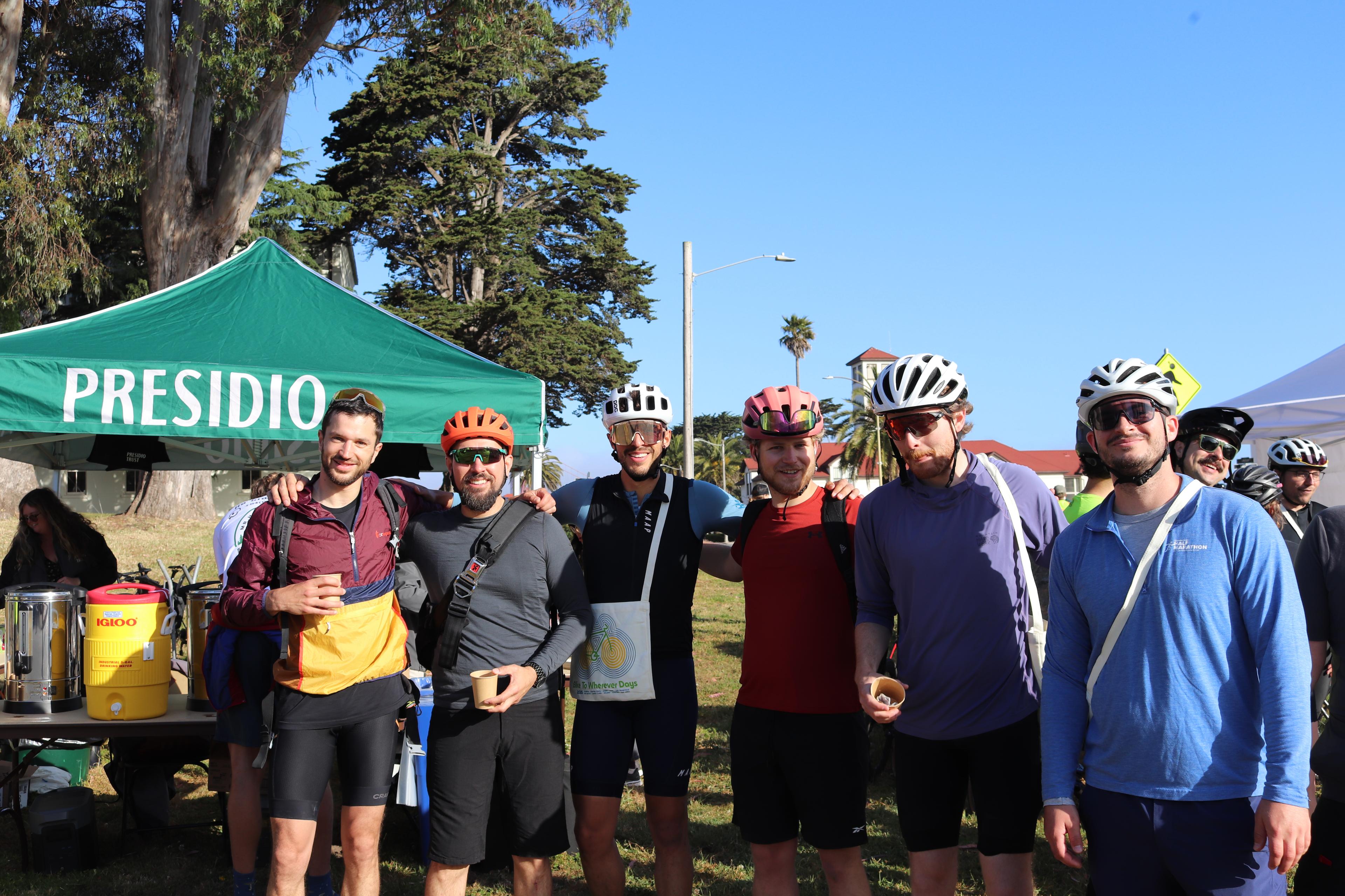 Group of men with arms around each others shoulders for bike to work day