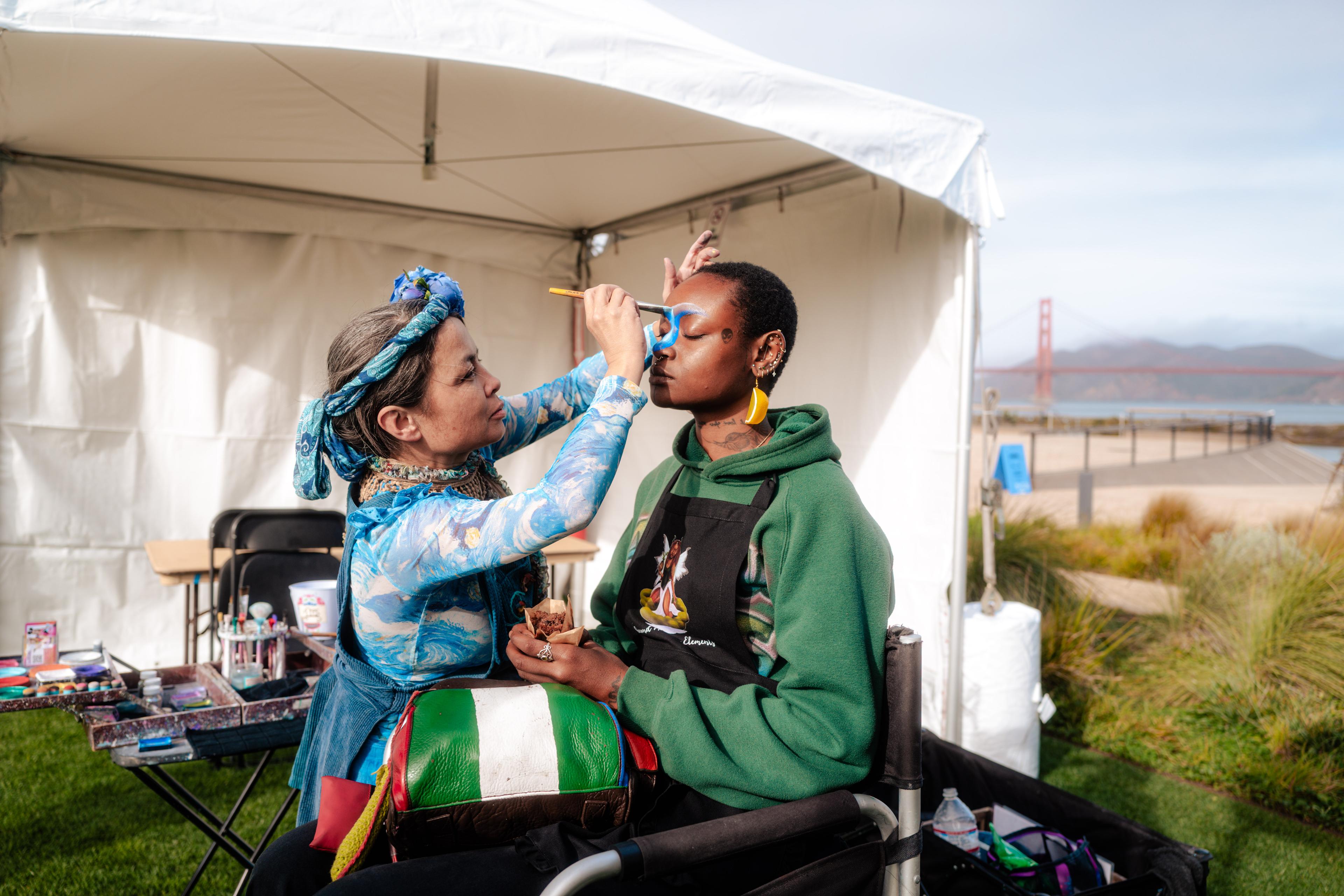 woman putting face paint on another woman