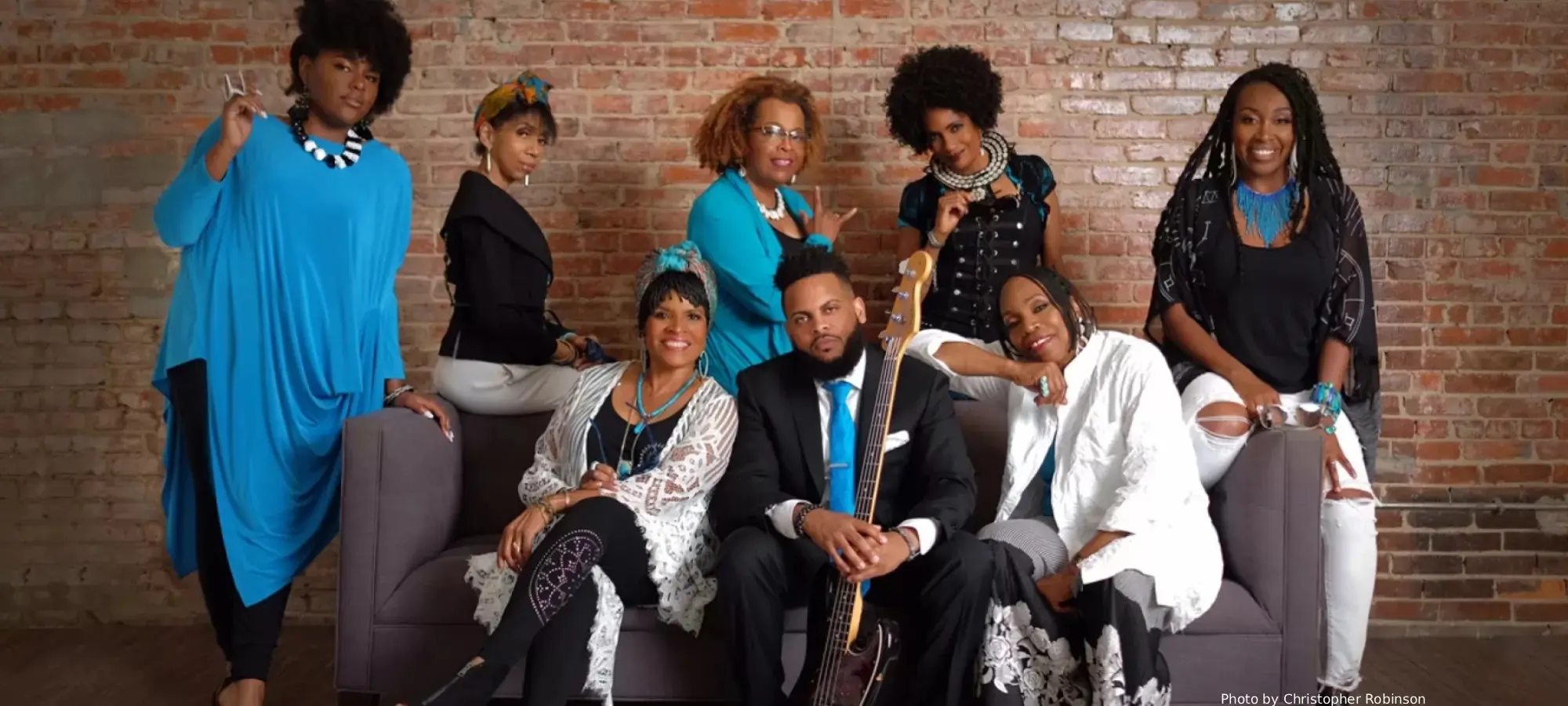 Musical group of eight men and women posing together