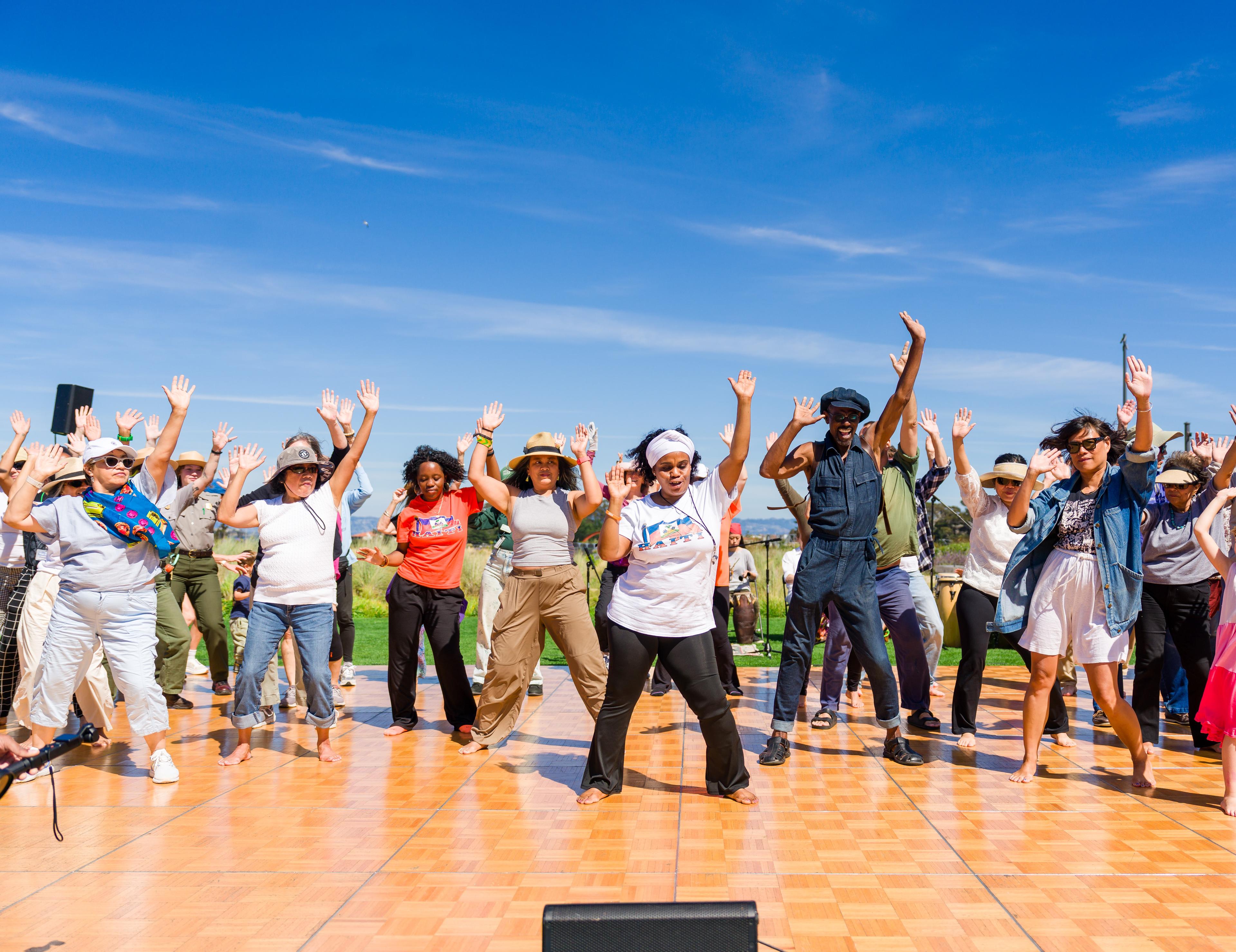A group of people dancing on a wooden dance floor at the Presidio Tunnel Tops