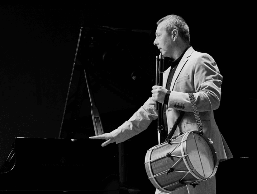 man singing with an instrument into darkness