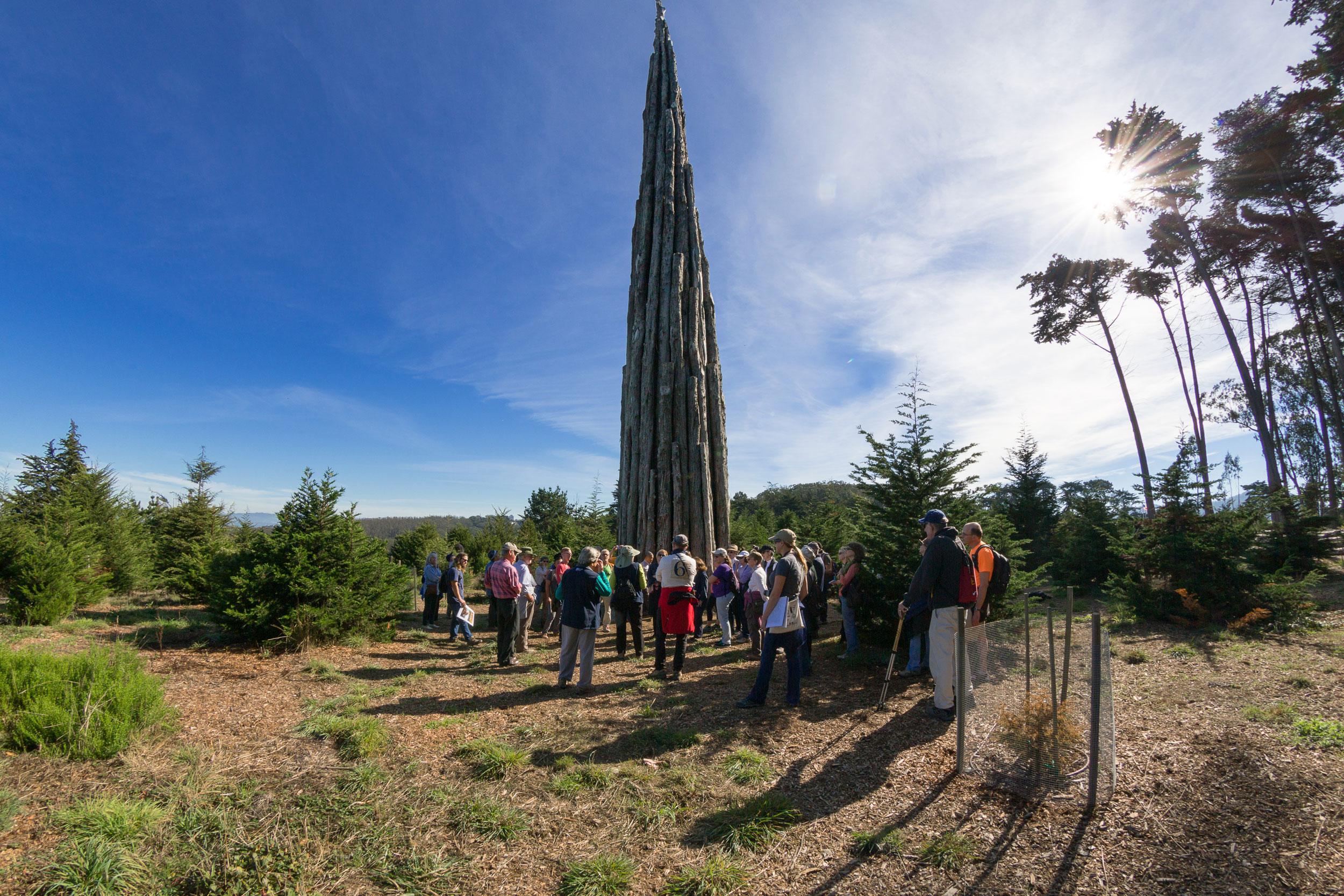 Group of visitors in front of tall Spire art