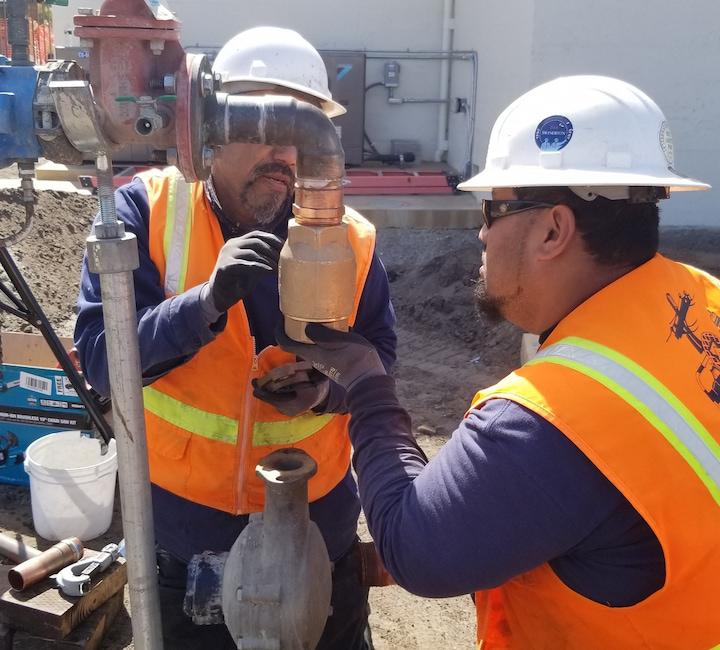 Two Presidio Trust staff members work on a water project.