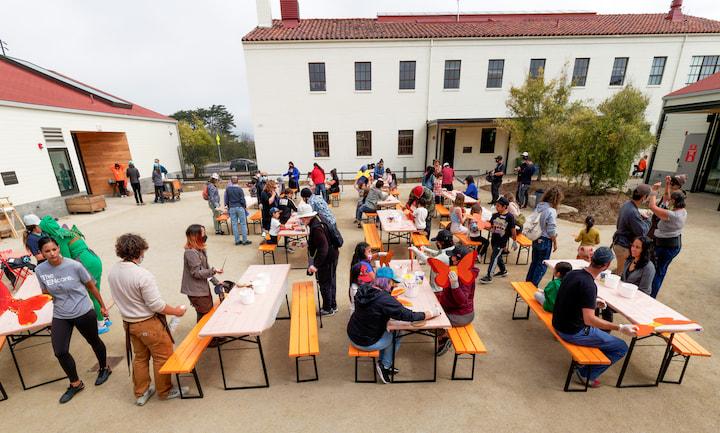 Kids outdoors at picnic tables at the Crissy Field Center courtyard.