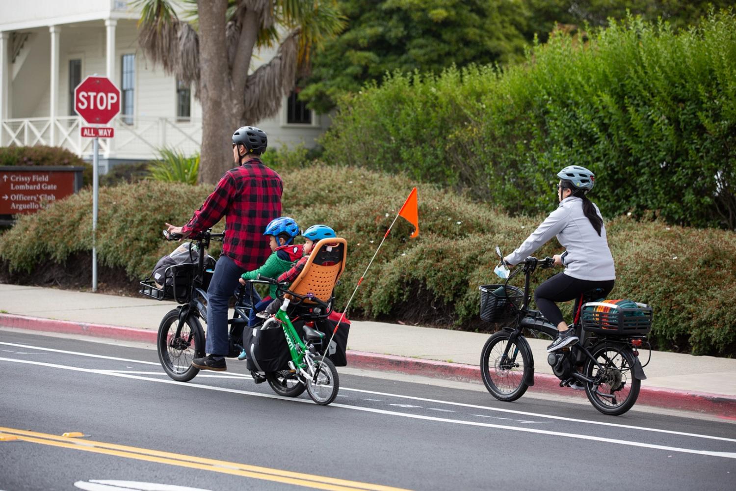 A man, a woman, and two children riding bicycles in the Presidio. Photo by Myleen Hollero.
