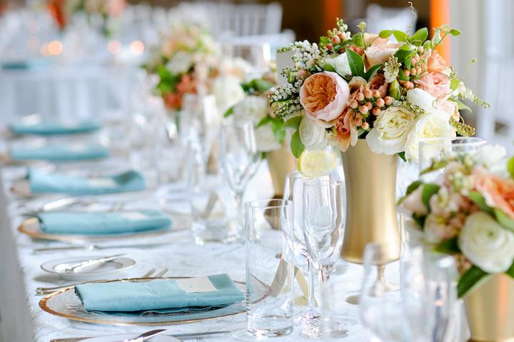 Table at an event with florals and linens.