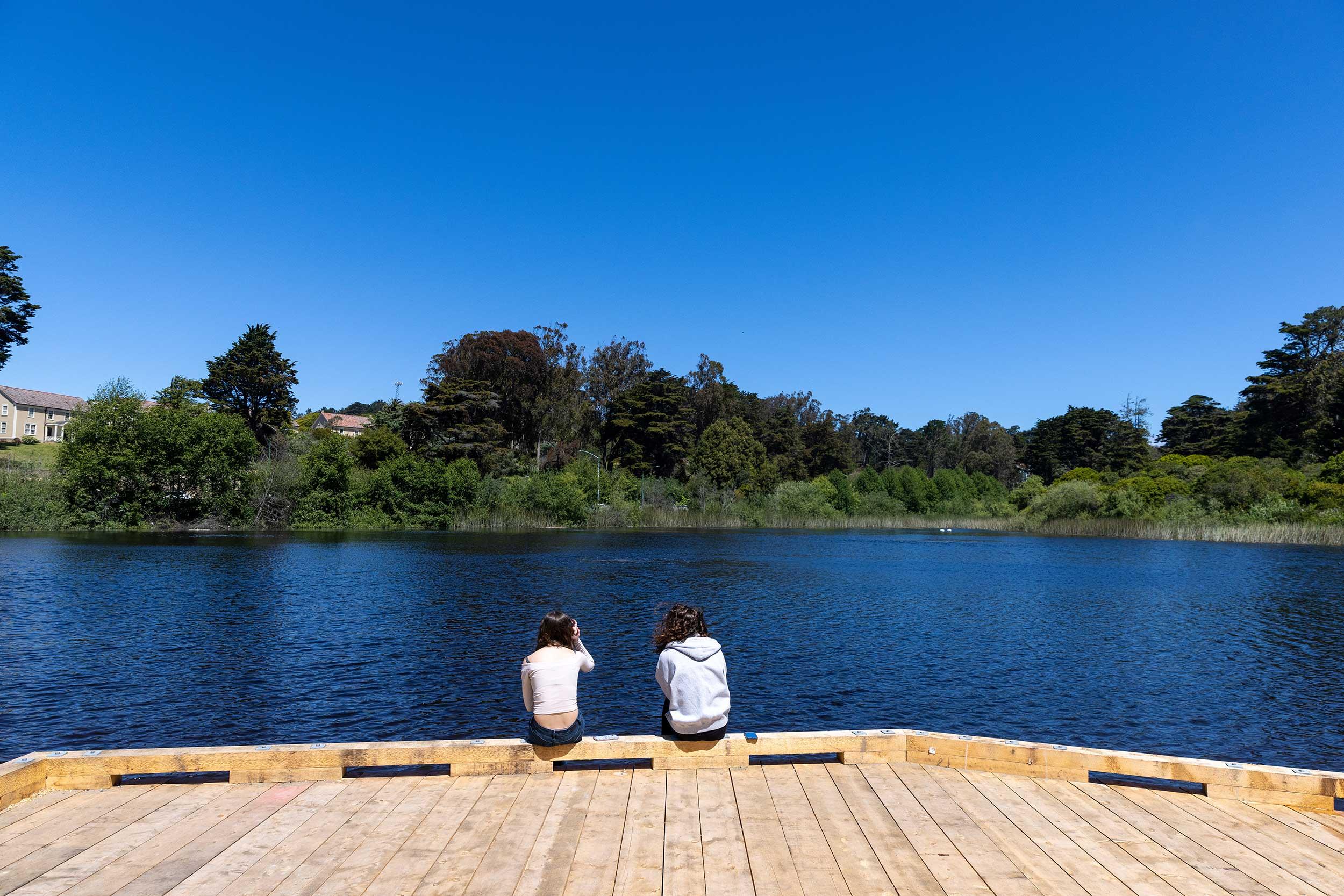 Two people sitting on the edge of Mountain Lake. Photo by Myleen Hollero.