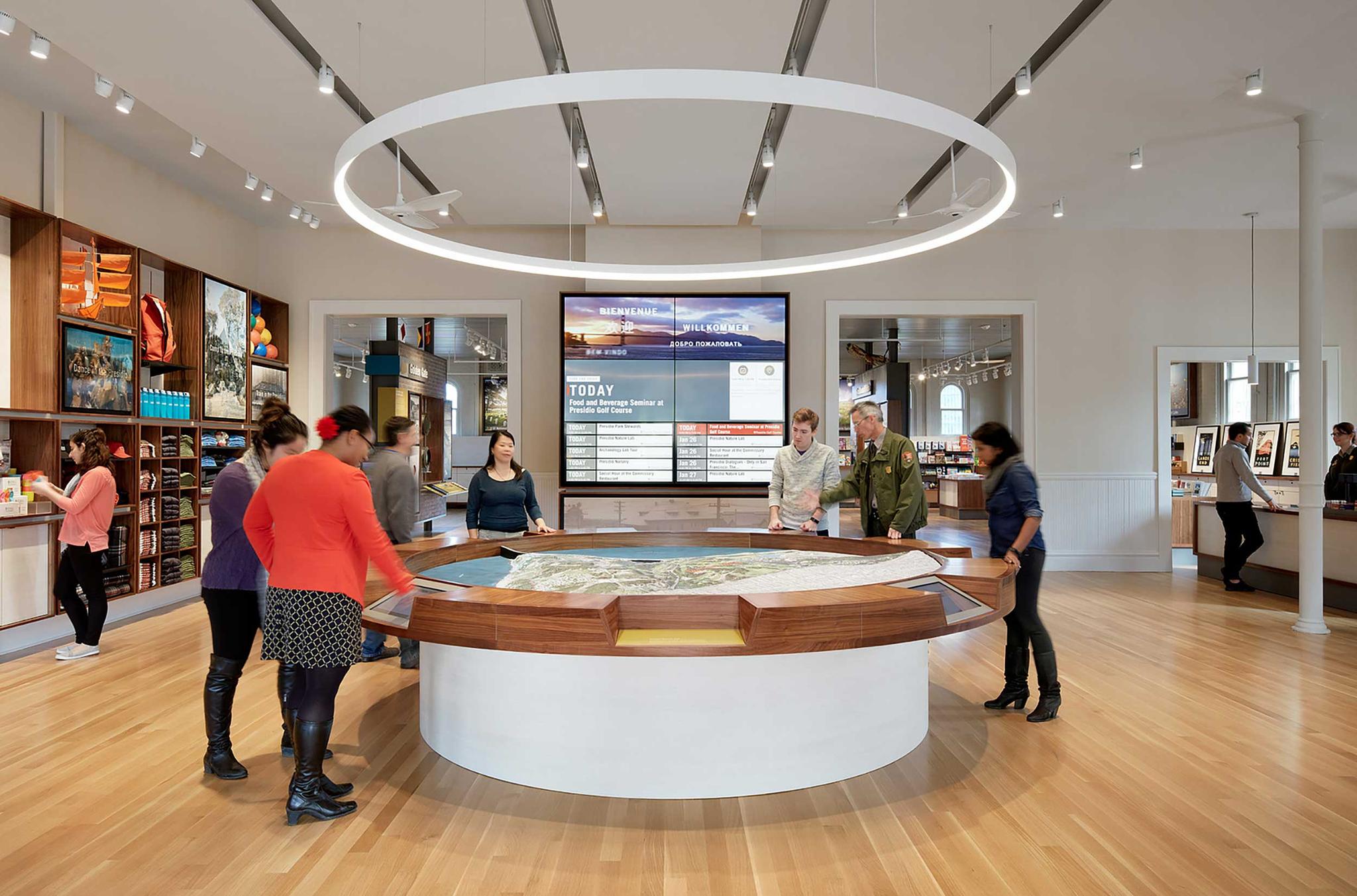 Interior of the Presidio Visitor Center, with people viewing a large Presidio model. Photo by Matthew Millman.