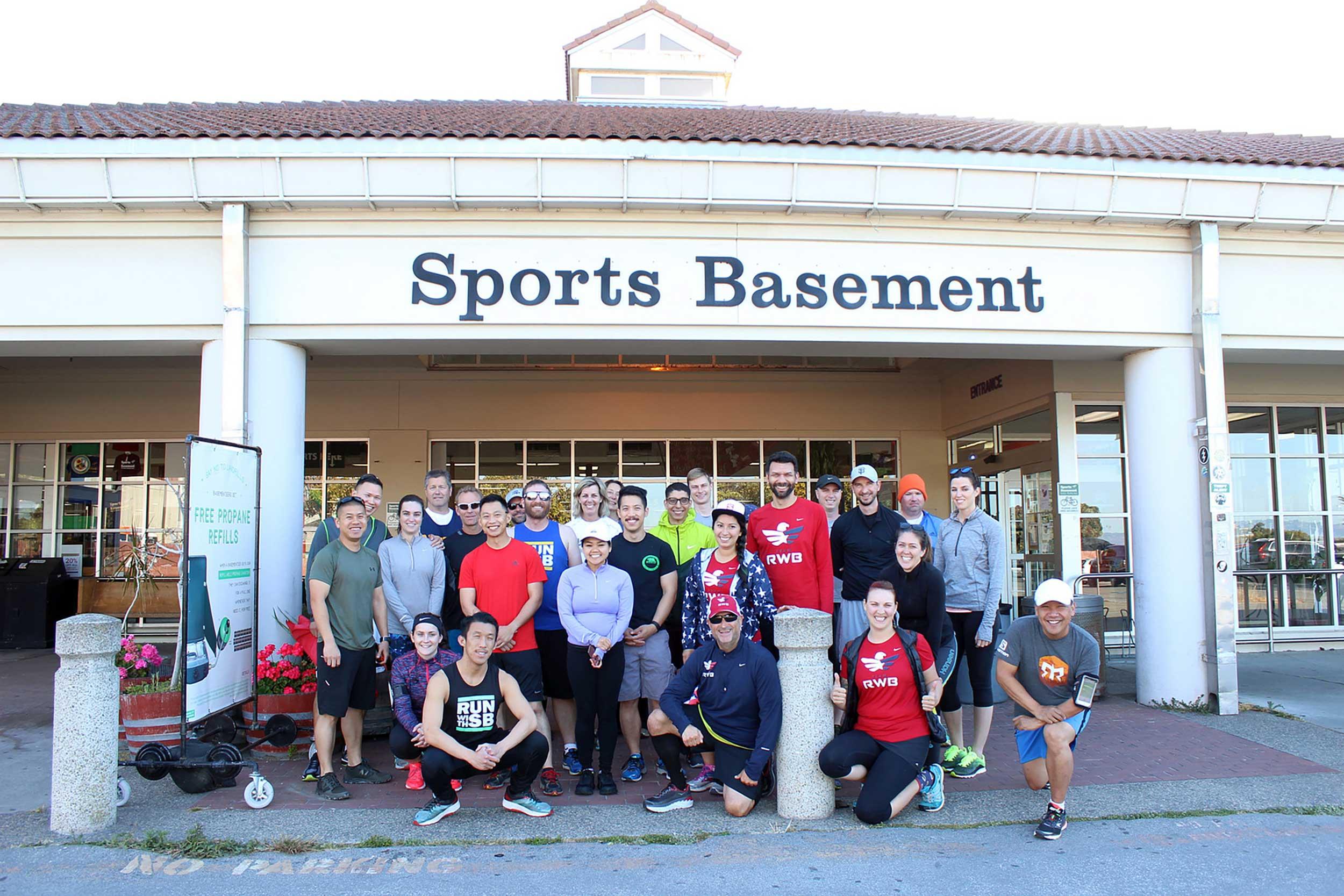 A group of people gathered for an event in front of Sports Basement in the Presidio.