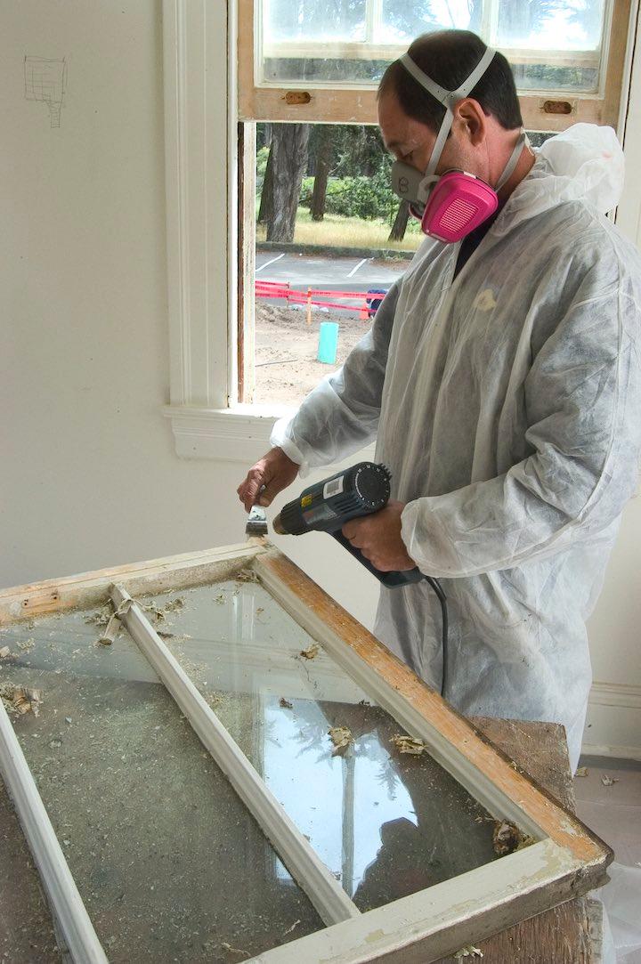 Worker repairs a historic Presidio window.