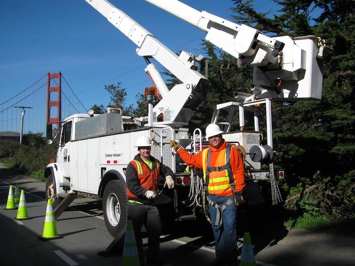 Two Presidio Trust high voltage staff members standing in front of a truck.