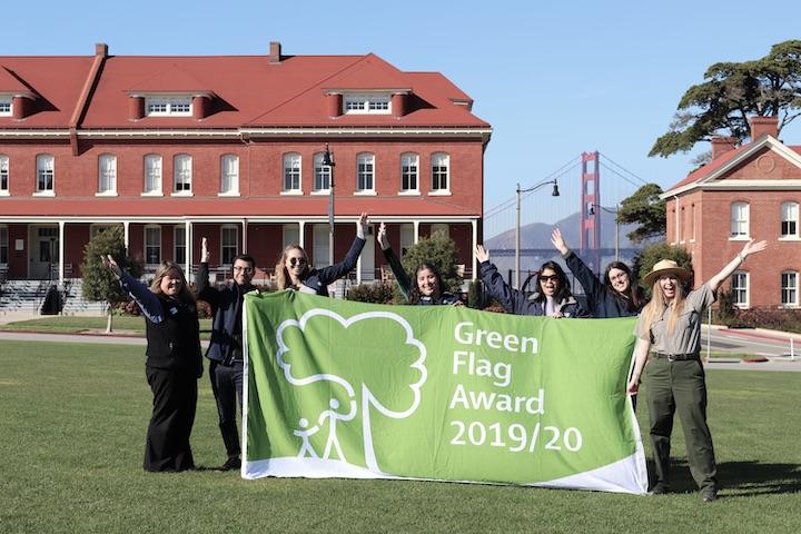 Staff of the Partnership for the Presidio hold the Green Flag award banner.