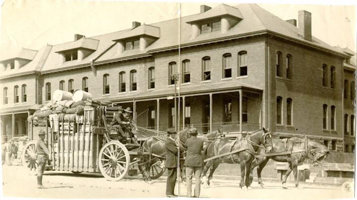Historic photo of a horse and wagon in front of the Montgomery Street Barracks.