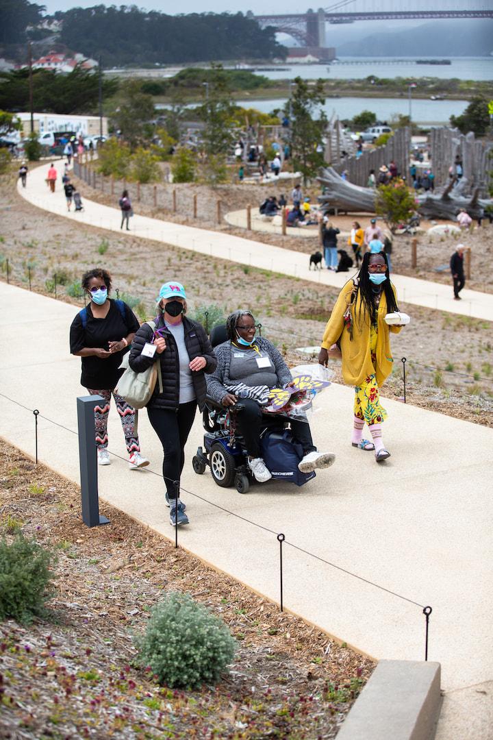 Four women, one seated in a wheelchair, are on a path at Presidio Tunnel Tops. Photo by Myleen Hollero.