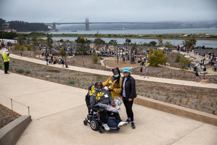 A visitor in a wheelchair and two other visitors on a pathway at Presidio Tunnel Tops. Photo by Myleen Hollero.