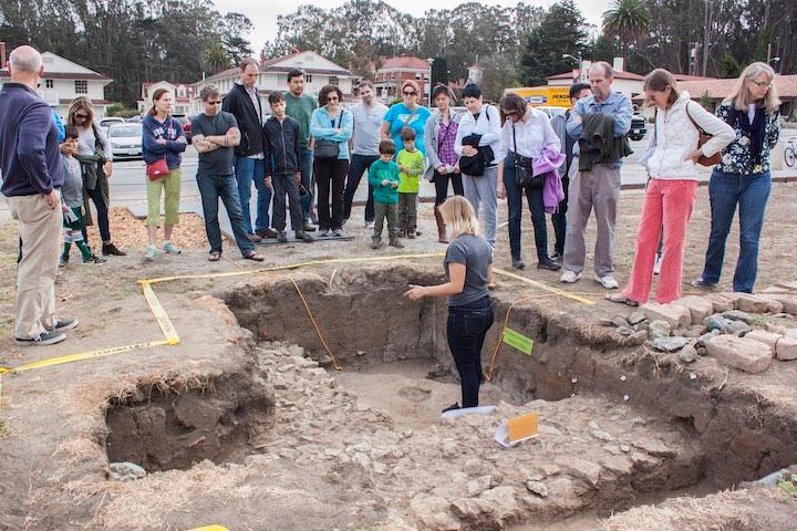 Woman leading a large archaeology tour at the Presidio.