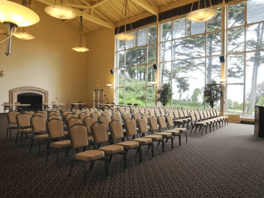 A room set up for a conference or meeting with lined chairs.